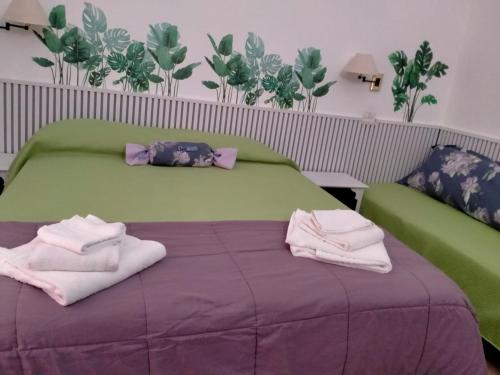 1 dormitorio con 1 cama con toallas en Rodoflor Rooms, en Castellammare di Stabia