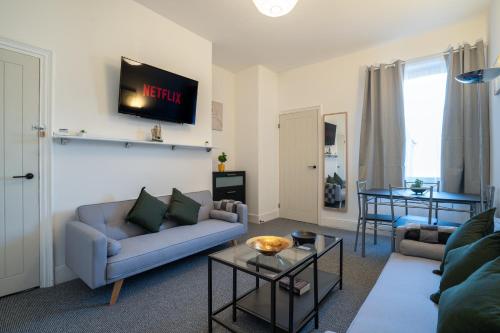 a living room with a couch and a table at Cozy 3 Bed Apartment - Parking in Gateshead