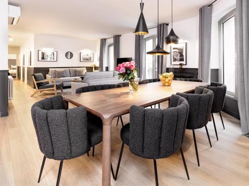 une salle à manger avec une table et des chaises en bois dans l'établissement LivinParis - Luxury A/C 3 Bedrooms Opera III, à Paris