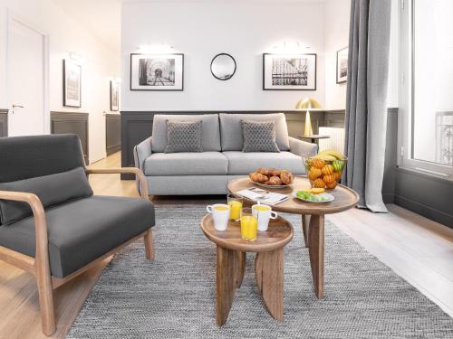 - un salon avec un canapé et une table avec des fruits dans l'établissement LivinParis - Luxury A/C 3 Bedrooms Opera III, à Paris