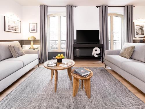 un salon avec deux canapés et une table basse dans l'établissement LivinParis - Luxury A/C 3 Bedrooms Opera III, à Paris