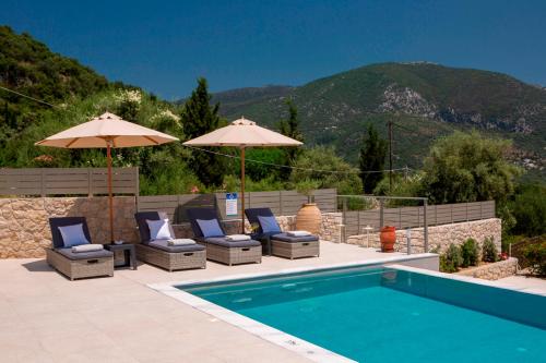 a swimming pool with chairs and umbrellas next to a swimming pool at Villa Marianna II in Nydri
