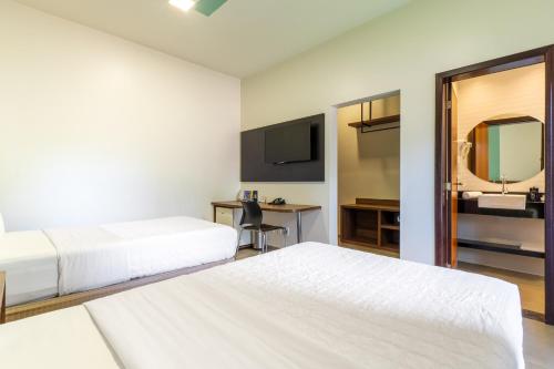 a bedroom with two beds and a desk with a mirror at Ucayali Hotel in Sinop