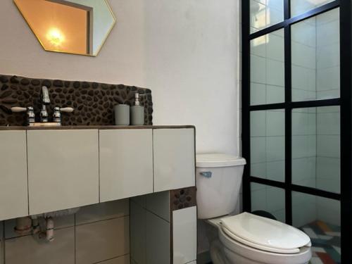 La salle de bains blanche est pourvue de toilettes et d'un miroir. dans l'établissement La casa del Río Las luciérnagas By Rotamundos, 