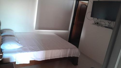 niewielka sypialnia z łóżkiem i oknem w obiekcie Balcony Guatapé w mieście Guatapé