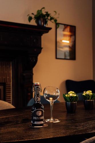 a bottle of beer and a glass on a table at Maison d'hôte Brasserie Caulier in Péruwelz