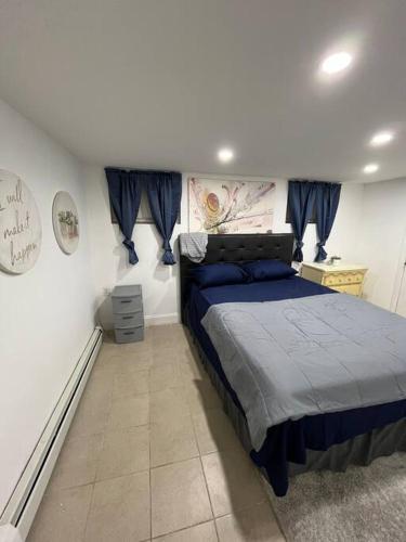 a bedroom with a bed with blue sheets on it at 2 Bedroom Apartment By Airport in Hillside