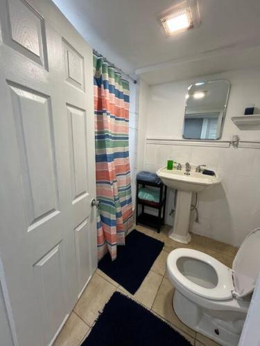 a bathroom with a toilet and a sink at 2 Bedroom Apartment By Airport in Hillside