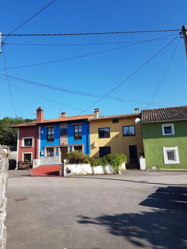 a row of colorful houses on a street at apartamentos rurales marrubiu-playa de Poo in Llanes