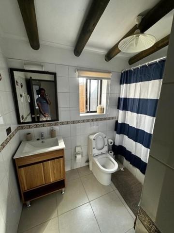 a bathroom with a sink and a toilet and a mirror at La casa del Mar en Guanaqueros! in Guanaqueros