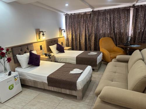 une chambre d'hôtel avec deux lits et un canapé dans l'établissement Beyond OTEL, à Antalya