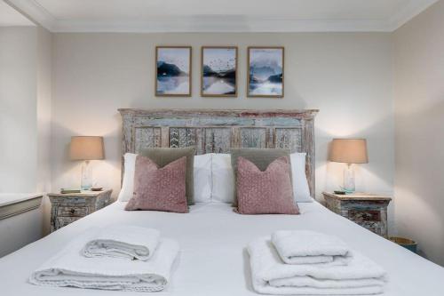 a bedroom with a large white bed with towels on it at The Tranquil Auchterarder 3-bed Cottage in Auchterarder