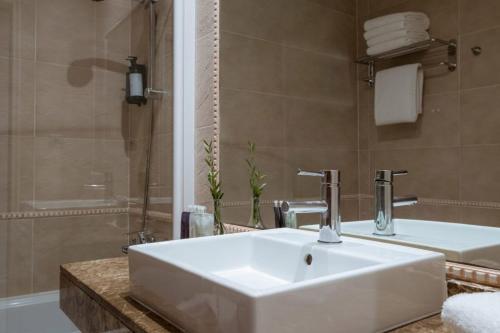 y baño con lavabo blanco y ducha. en Hotel Montjoi by Brava Hoteles, en Sant Feliu de Guíxols
