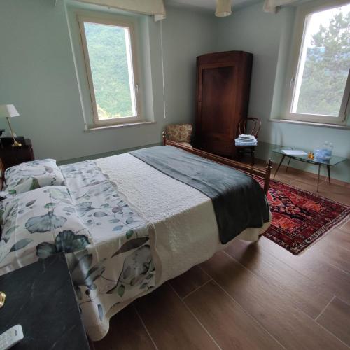 a bedroom with a bed and two windows at CantoQuinto Bed and Breakfast in Fivizzano