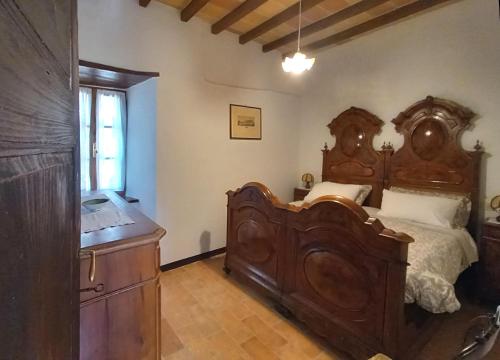 a bedroom with a large wooden bed and a dresser at B&B CorteBonomini entire home in Sasso