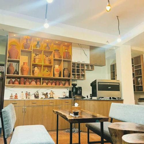 a kitchen with a table and some vases on shelves at Cosy Hotel in Bhaktapur