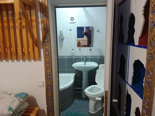 une salle de bain avec toilettes, lavabo et miroir dans l'établissement Ark & Yulduz, à Boukhara