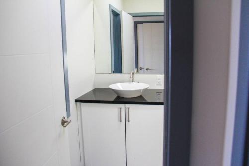 a bathroom with a white sink and a mirror at SkyTime Vacations in Wellington