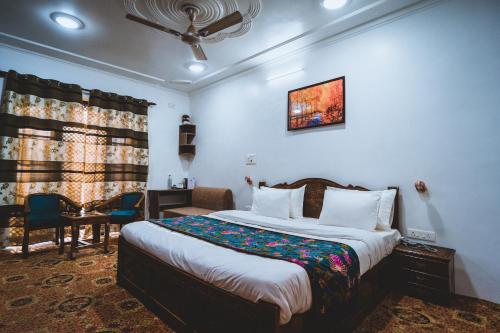ein Schlafzimmer mit einem Bett, einem Tisch und einem Stuhl in der Unterkunft The Mallard by Evoke Hotels in Srinagar