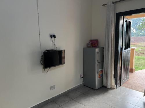 a tv on the corner of a wall with a refrigerator at Beautiful 1-Bed Apartment in Gulu in Gulu