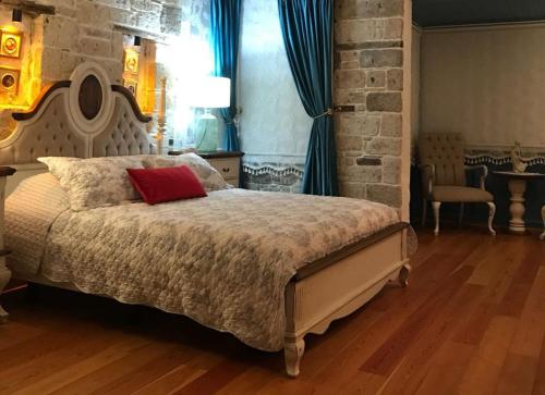 a bedroom with a bed with a red pillow on it at VİA PERLA BUTİK OTEL in Çiftlikköyü