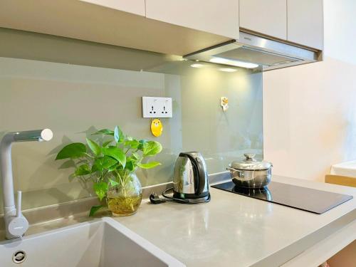 a kitchen counter with a tea kettle and a sink at The Song QA Apartment in Vung Tau