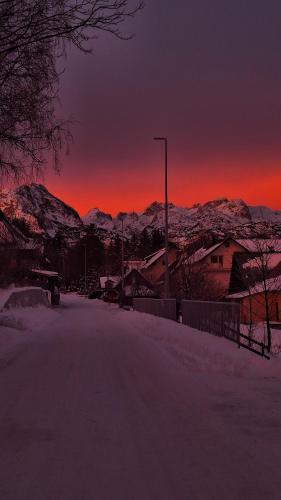 a snowy street at sunset with mountains in the background at Apartman A&J in Žabljak