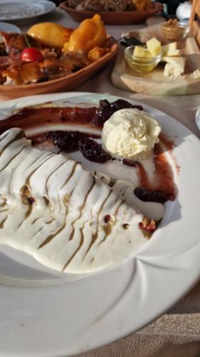 a white plate with a dessert with sauce and ice cream at Apartmani Vila Marija in Budva