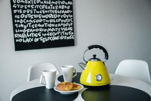 una tetera amarilla sobre una mesa con un plato de comida en Departamento Lima en Tandil