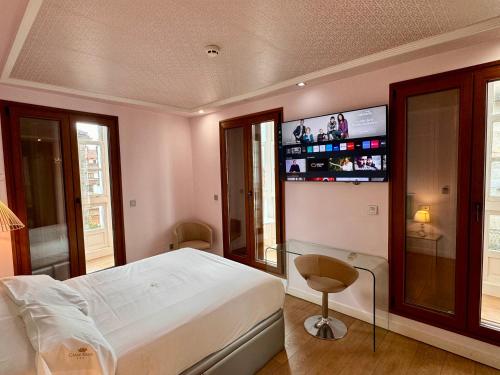 1 dormitorio con 1 cama y TV en la pared en Casas Reais Boutique, en Santiago de Compostela