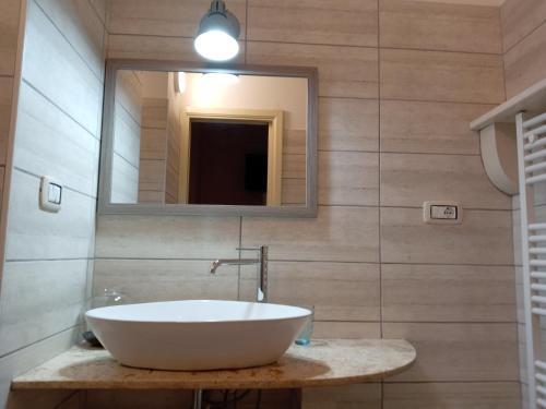 a bathroom with a white sink and a mirror at Piazza Verdi Liberty House in Lecce