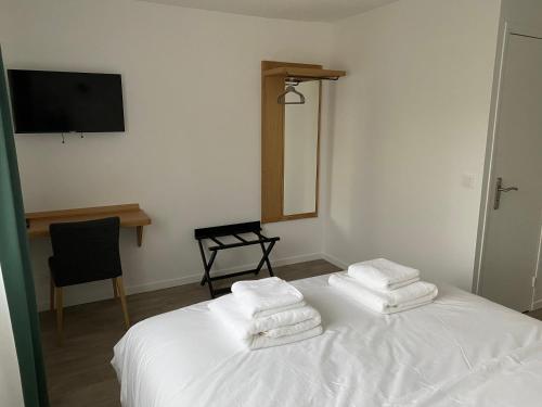 a bedroom with a white bed with towels on it at C La Suite in Pomponne