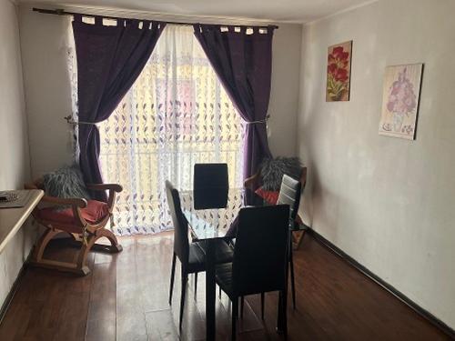 een eetkamer met een tafel en stoelen en een raam bij Piso 5 Con estacionamiento - Sin Ascensor in Copiapó