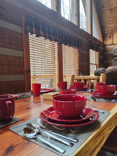 a table with red dishes on a wooden table at Meadows Way 3378 in Pigeon Forge