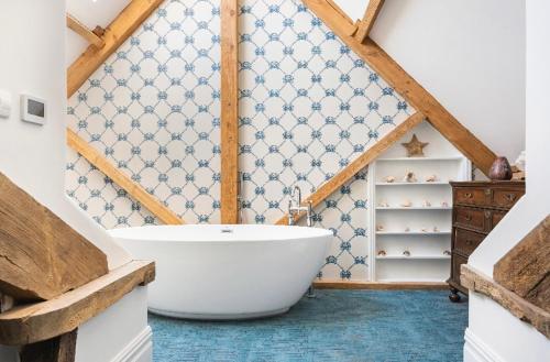 a bathroom with a white bath tub in a attic at The Pink House in Brecon