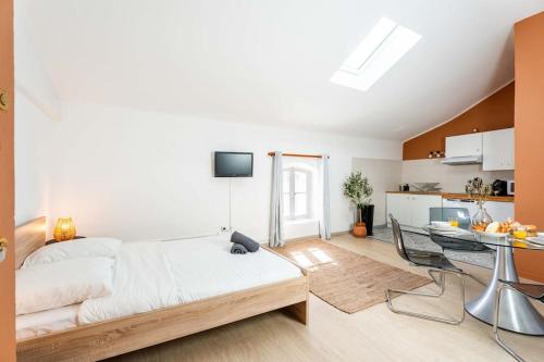 une chambre avec un lit et une table et une cuisine dans l'établissement Double Studio au coeur des Marais Salants, à Arles