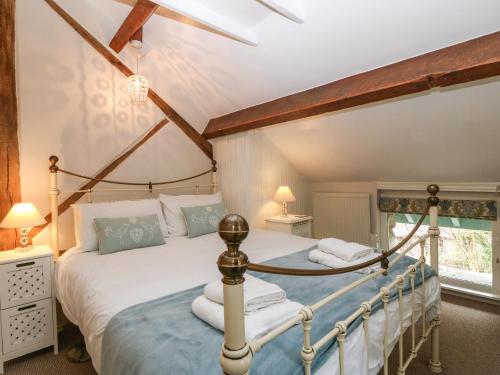 a bedroom with a canopy bed with white sheets at Millers Loft in Llanrwst
