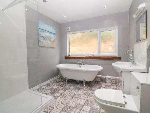 蘭魯斯特的住宿－Millers Loft，带浴缸、盥洗盆和卫生间的浴室