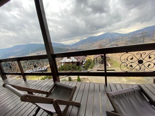 a balcony with two chairs and a view of mountains at AGORA Chalet in Slavske