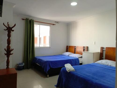 a bedroom with two beds and a window at Hotel Palma Real Cartagena in Cartagena de Indias