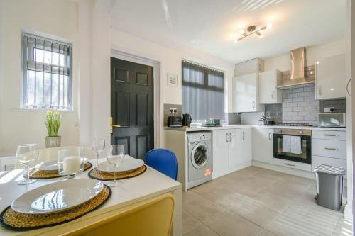 a kitchen with a table with wine glasses on it at Modern Home: Heart Of Blackburn in Blackburn