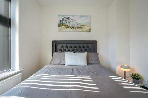 Modern Home: Heart Of Blackburn في بلاكبيرن: غرفة نوم مع سرير ولحاف رمادي