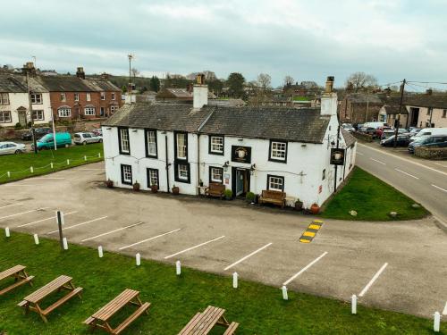 a large white building sitting next to a street at The Shepherds Inn, Langwathby in Penrith