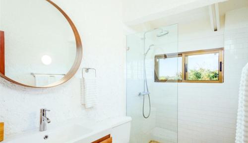La salle de bains est pourvue d'une douche et d'un miroir. dans l'établissement Newly Renovated 3 BR Golf Villa, à La Romana