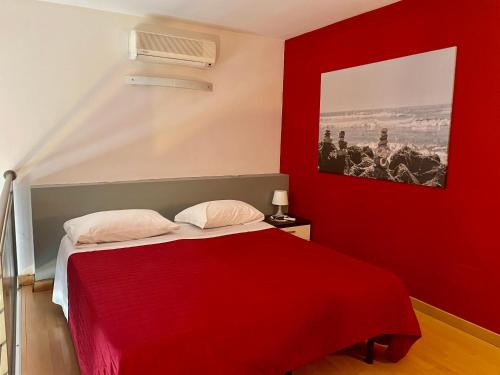 ein rotes Schlafzimmer mit einem Bett mit einer roten Decke in der Unterkunft Easy Space in Bientina