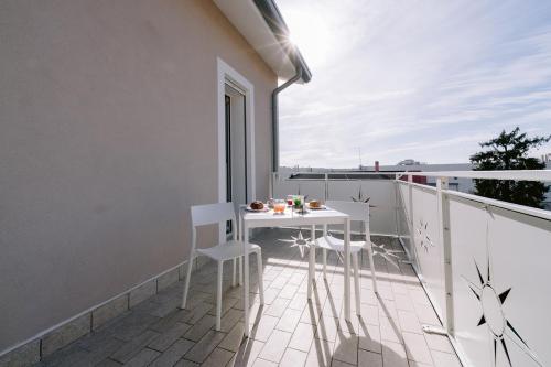 a balcony with a white table and chairs on it at Residenza La Boheme in Verona