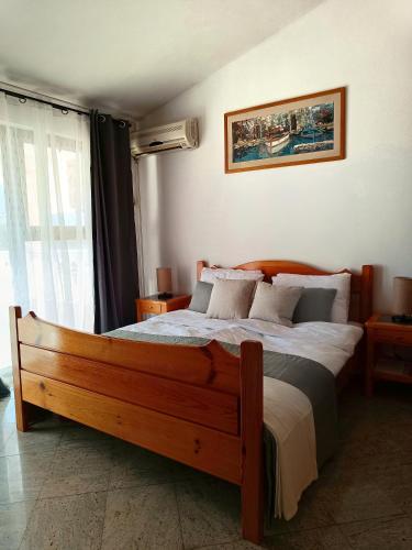 a bedroom with a large bed with a wooden frame at Vila Pašić in Igalo