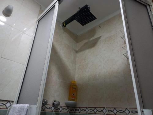 uma casa de banho com um chuveiro, um lavatório e um espelho. em APARTAESTUDIO DETRAS DE UNICENTRO em Armênia