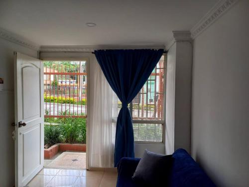 a living room with a blue curtain in front of a door at APARTAESTUDIO DETRAS DE UNICENTRO in Armenia