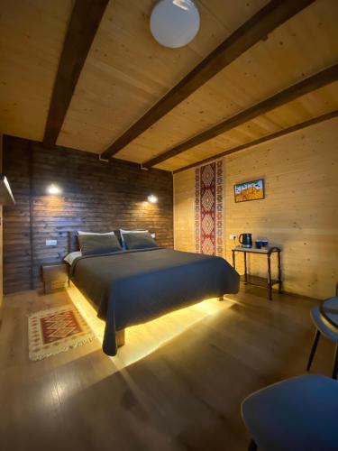 a bedroom with a bed and a wooden wall at AGORA Chalet in Slavske